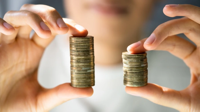 a man holding coins with both hands for salary transparency